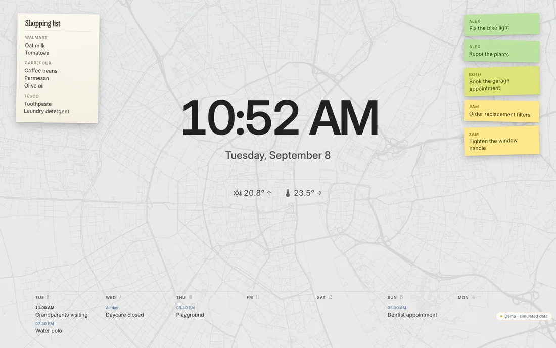 The standby screen: a large clock and date, temperatures below, the week along the bottom, reminders on the right, the shopping list on the left, over a faint street map.