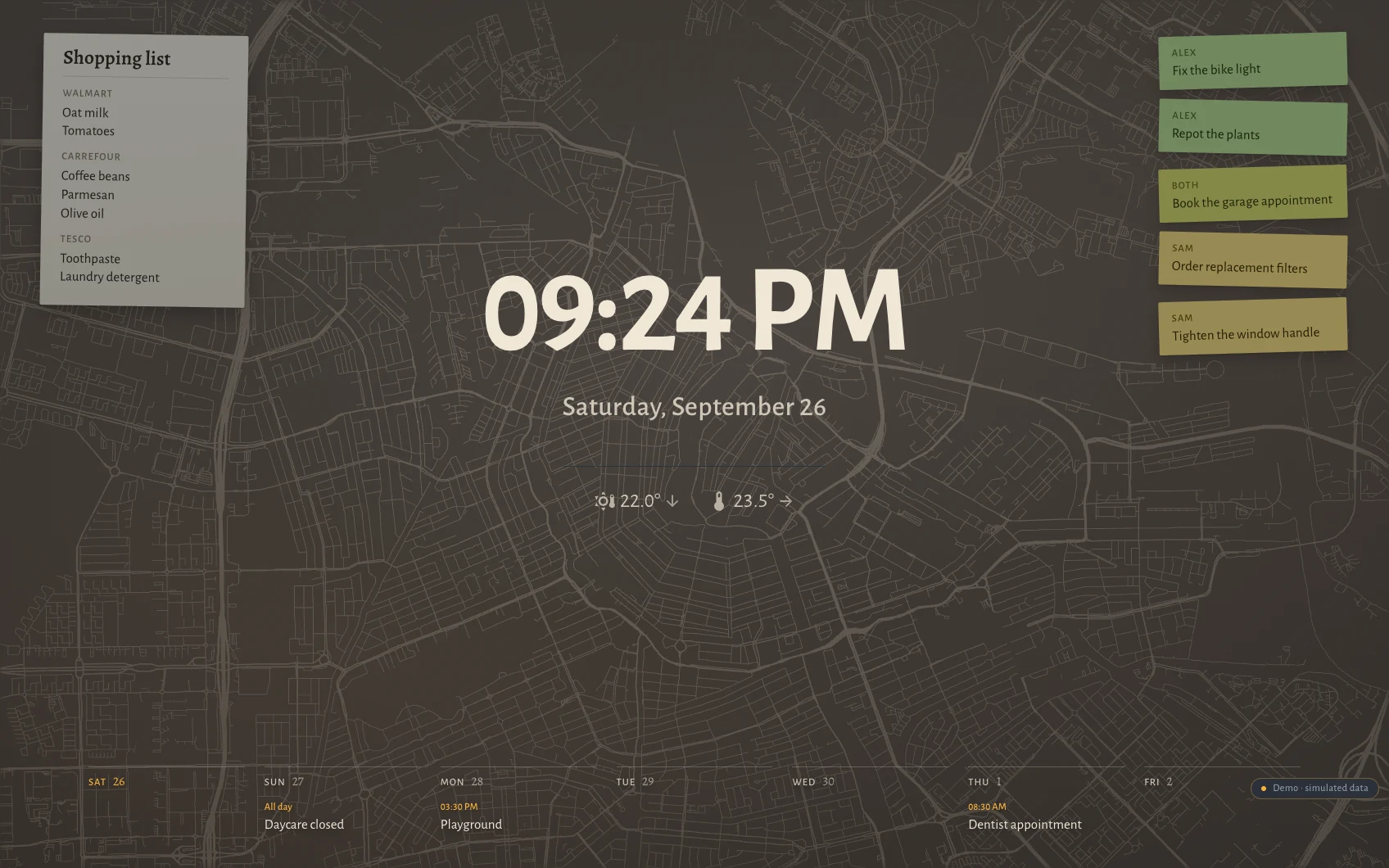 The Hauser standby screen at night in Amsterdam: clock, date, the week as seven columns along the bottom, post-its and the shopping list over a faint street map showing the canal rings drawn by their quays.