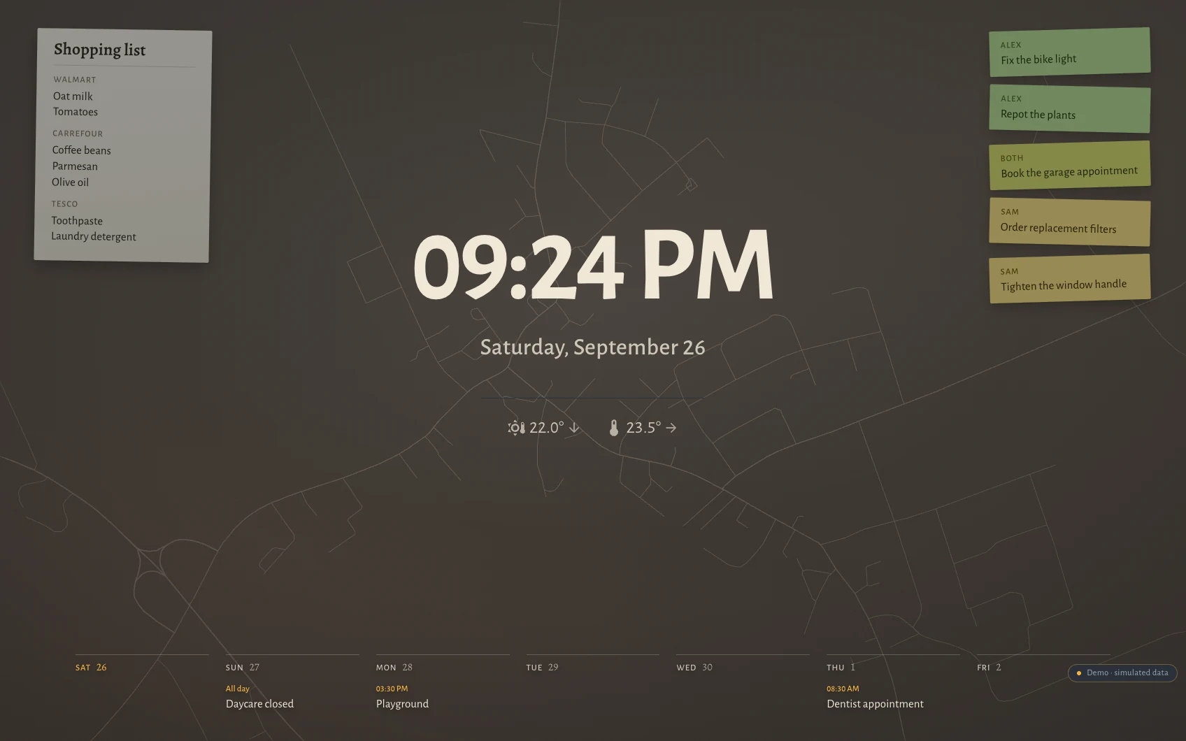 The Hauser standby screen at night in Petting, Bavaria: clock, date, the week as seven columns along the bottom, post-its and the shopping list over a faint street map showing a village: a handful of lanes.
